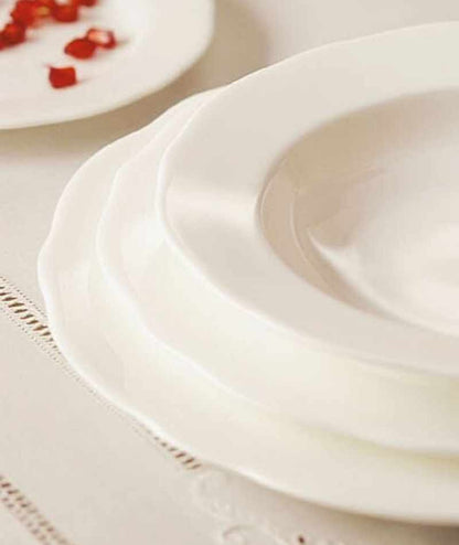 Dettaglio dei piatti KnIndustrie Armonia in Fine Bone China bianca apparecchiati