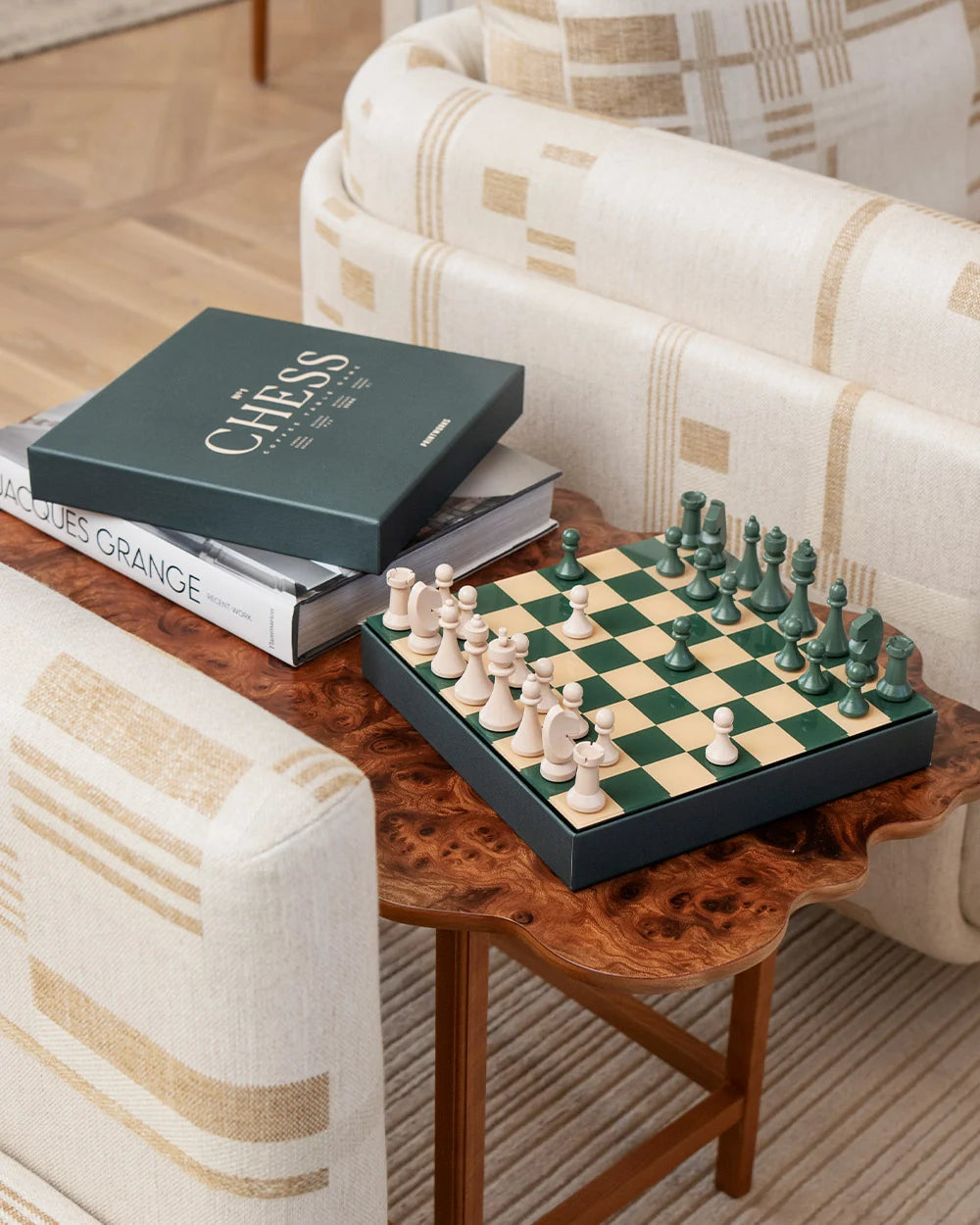 Scacchiera Printworks Chess Classic su un tavolino in legno accanto a libri e confezione
